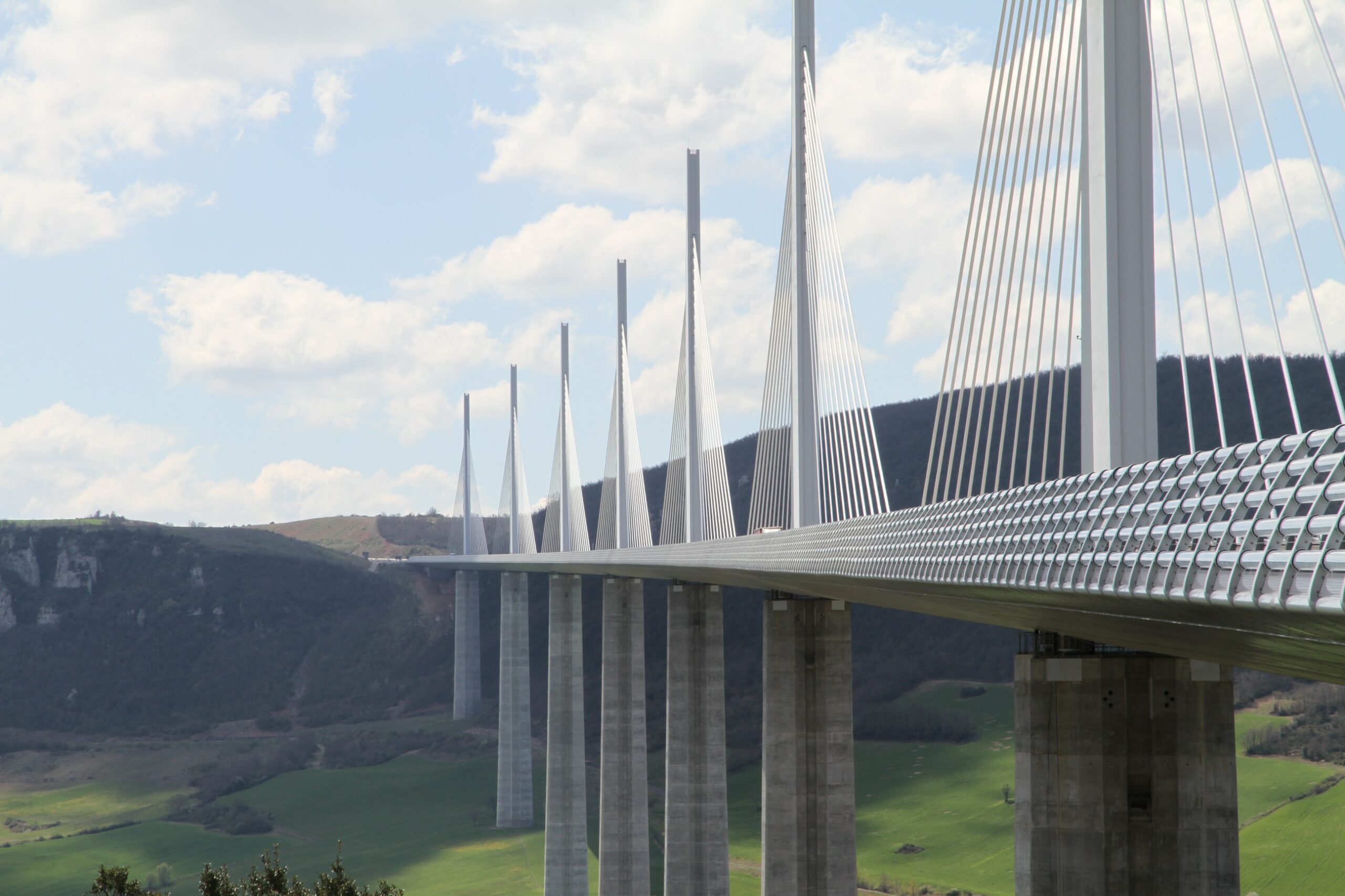 An enormous concrete cable stated bridge spanning a large valley